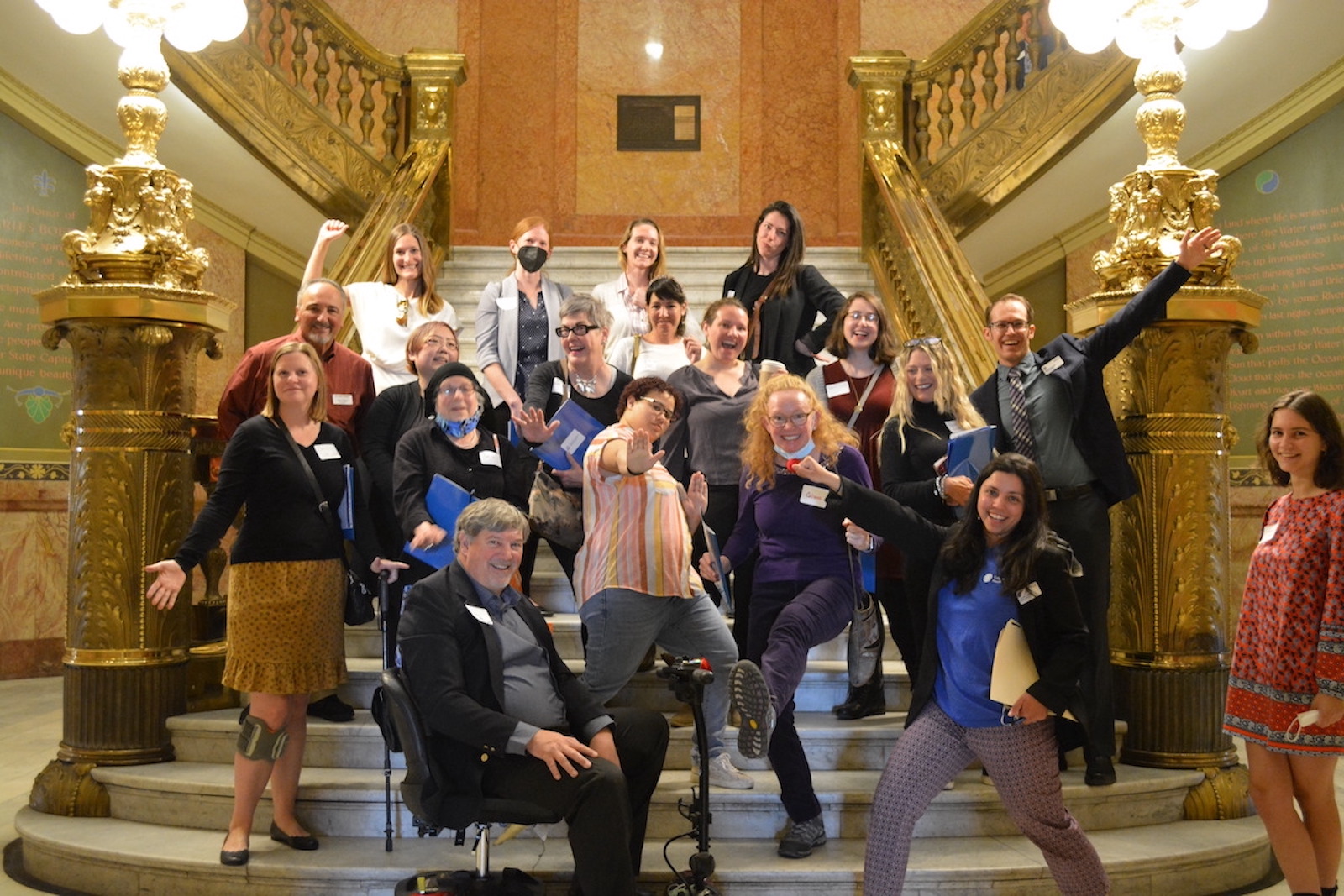 Group of CCHI staff and advocates posing in the Colorado Capitol taking a silly photo during health care day of action.