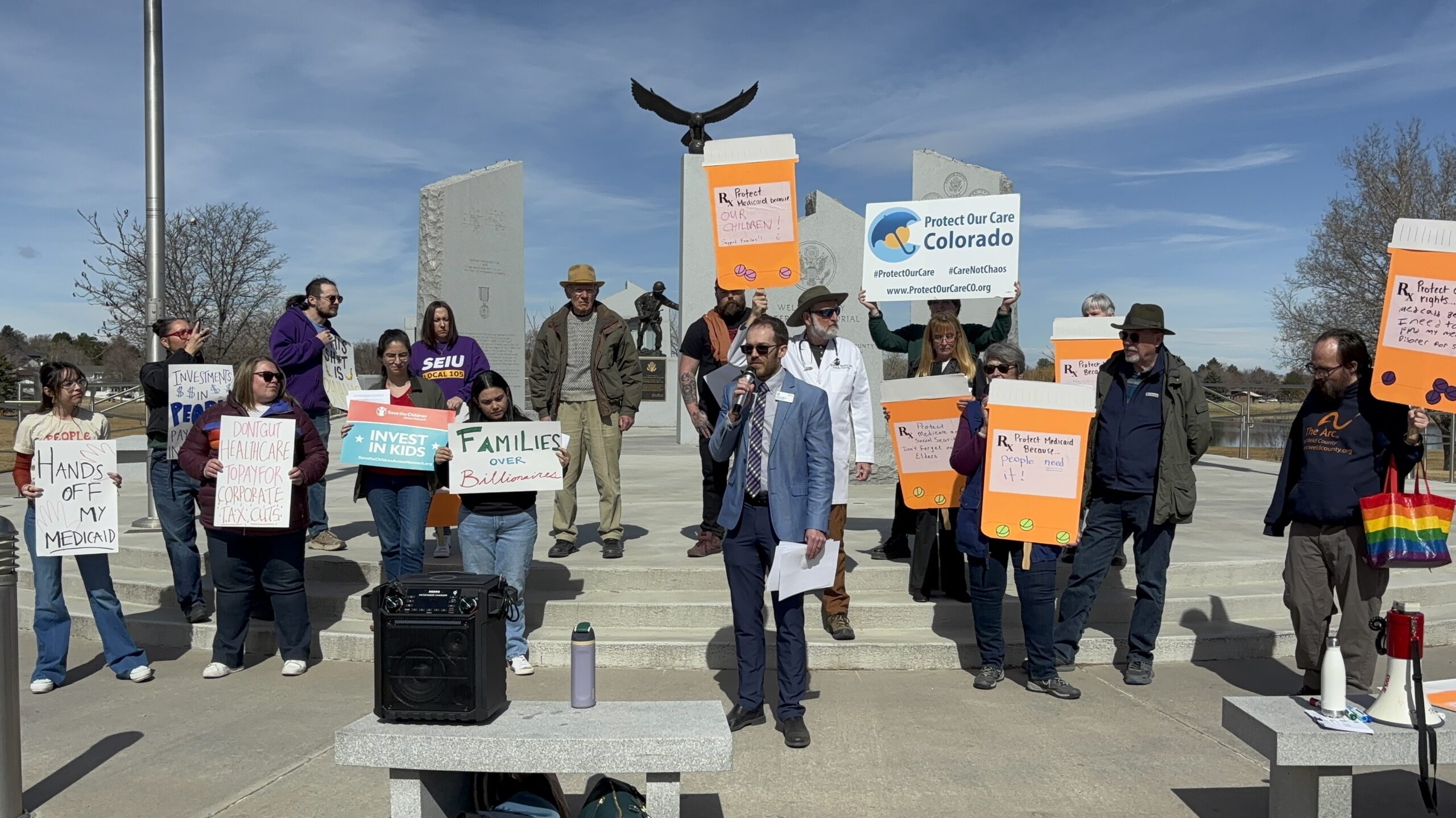 Large group of Coloradans outside the Colorado Capitol holding signs about necessity of health care. For example a sign saying Save My Care.